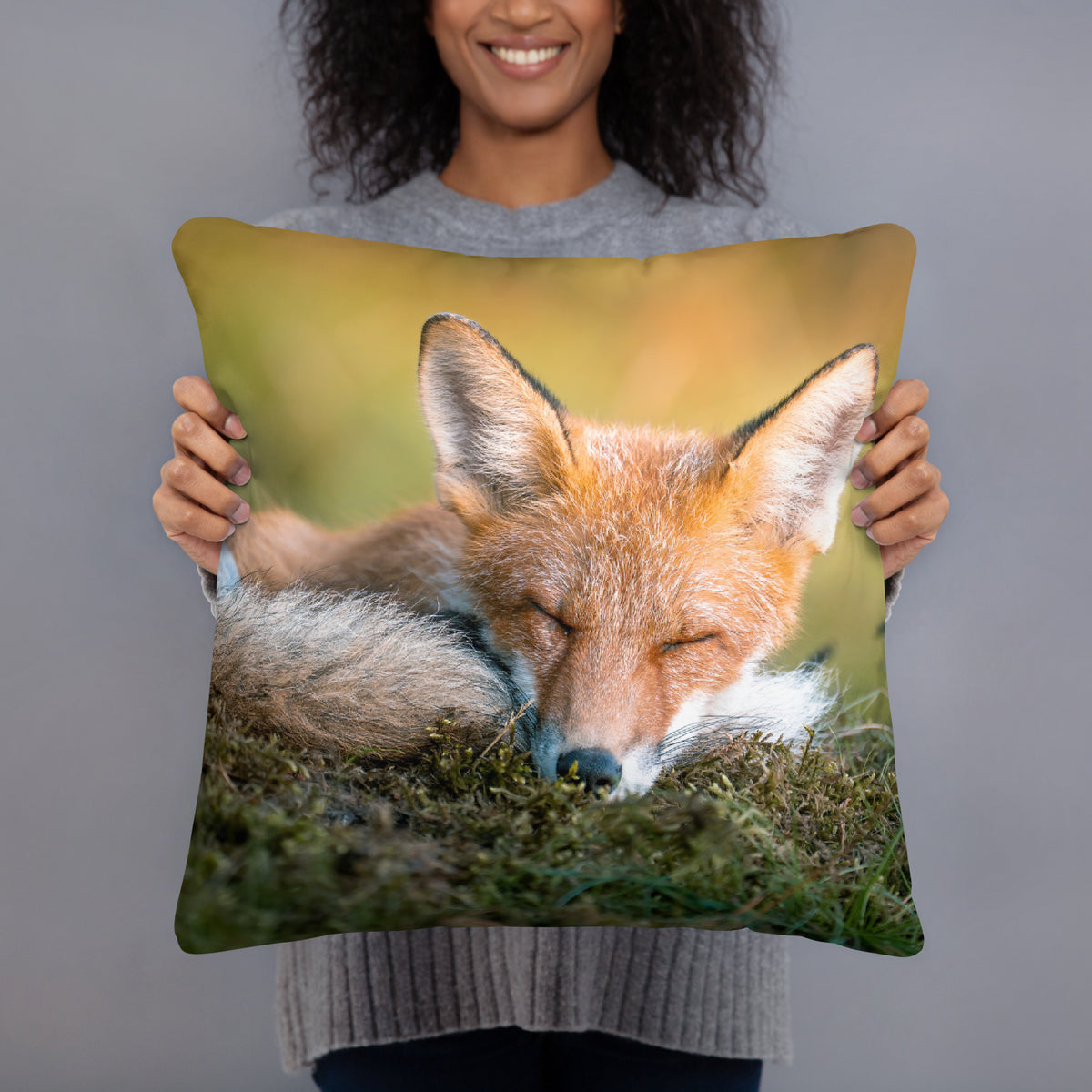 A person holding the soft 'Morning Nap' throw pillow, showcasing the heartwarming wildlife art and premium fabric