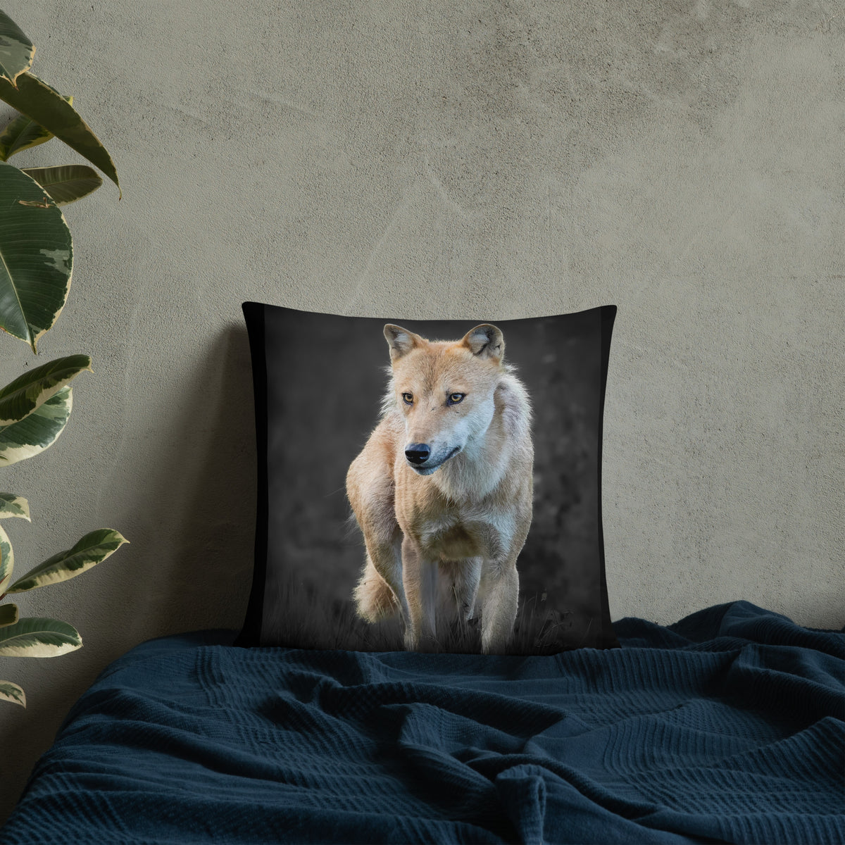 Novapuro x Auli Leivonen dark decorative throw pillow featuring a majestic Nordic wolf design, resting on a bed with dark blue bedding.