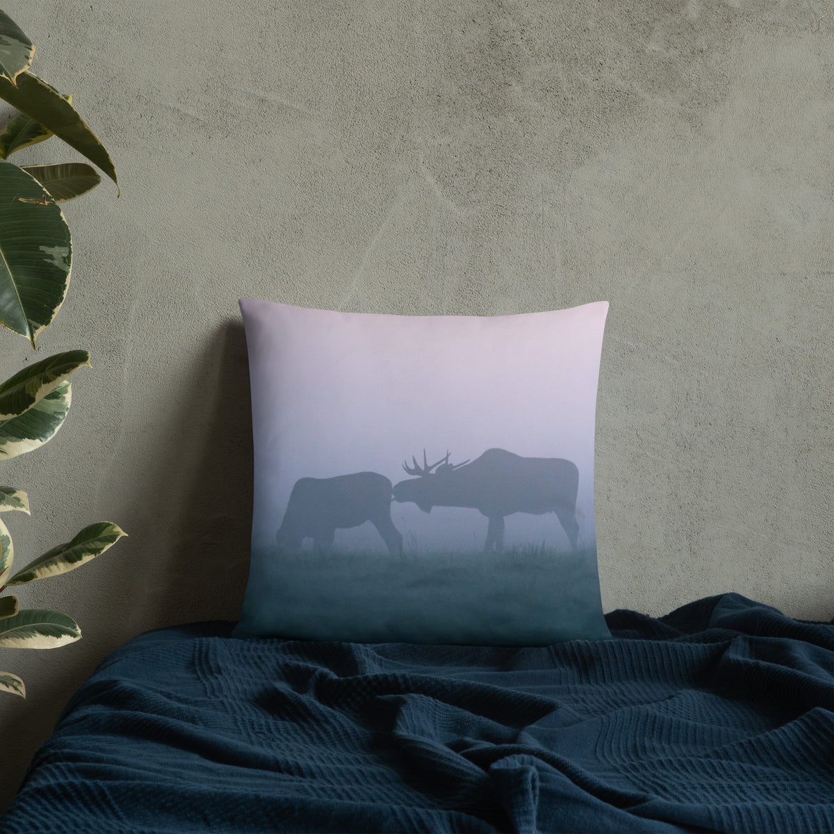 A stylish premium throw pillow featuring an original photograph of two moose in the mist by Mikko Monto, placed in a cozy home setting.