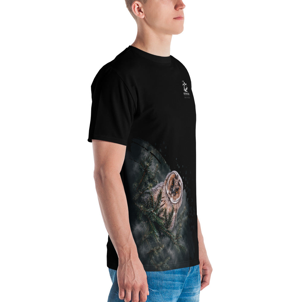 A man wearing the black Novapuro x Jarno Virtanen premium men's t-shirt featuring a Nordic long-eared owl chick print on the lower side.