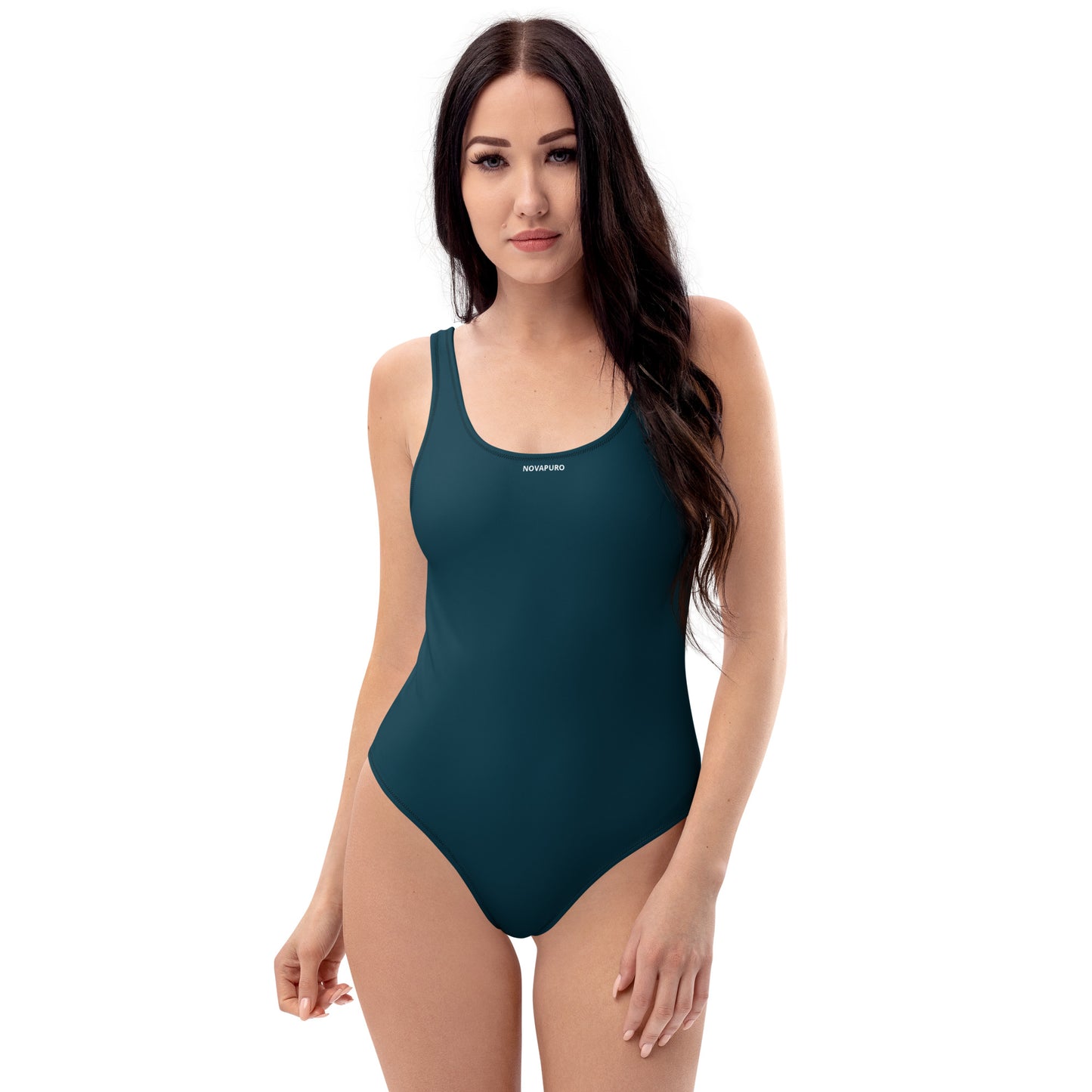 Model wearing deep ocean blue Novapuro Signature one-piece swimsuit with subtle chest logo