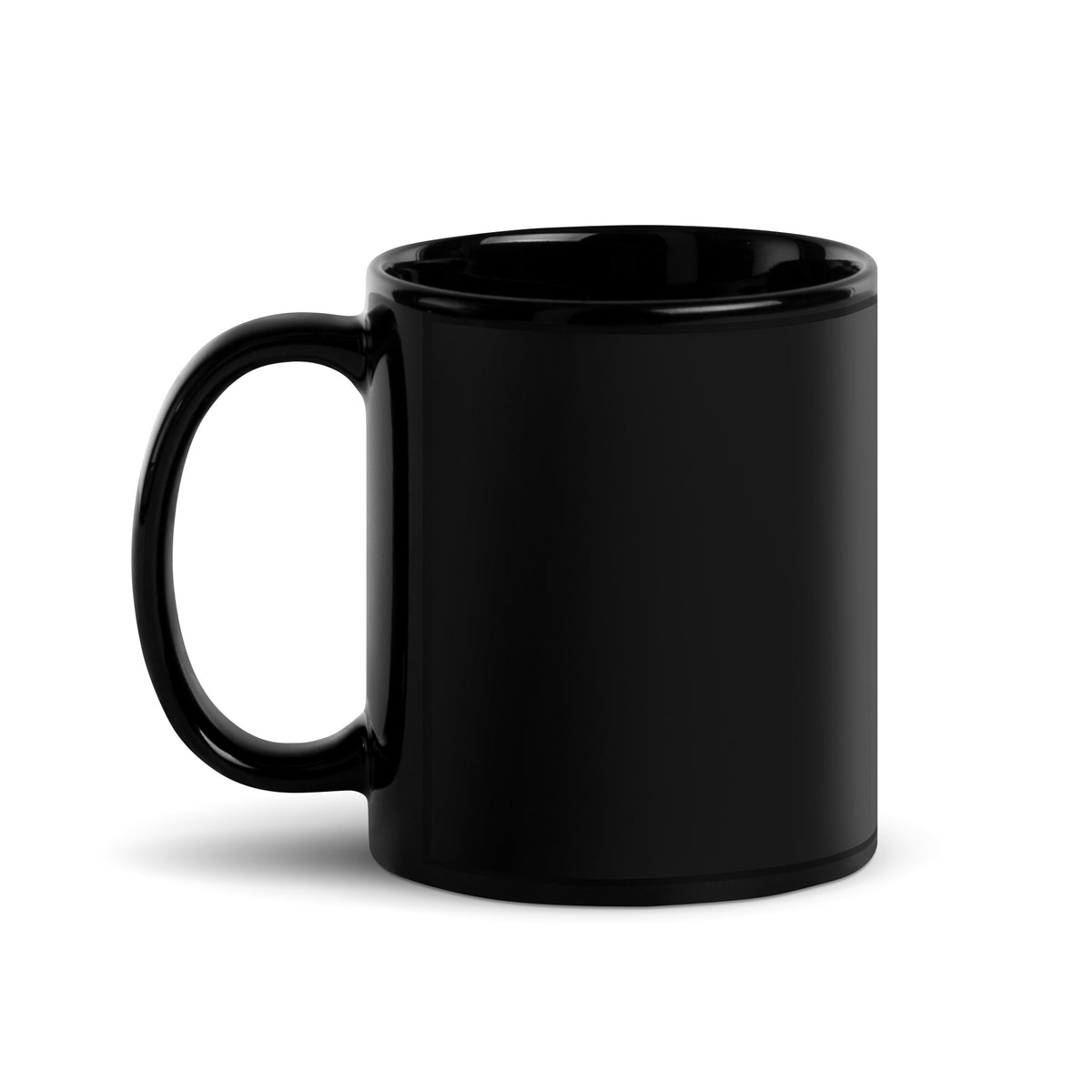 A black glossy ceramic mug featuring a Nordic long-eared owl chick print by Jarno Virtanen, sitting on a desk next to a notebook.