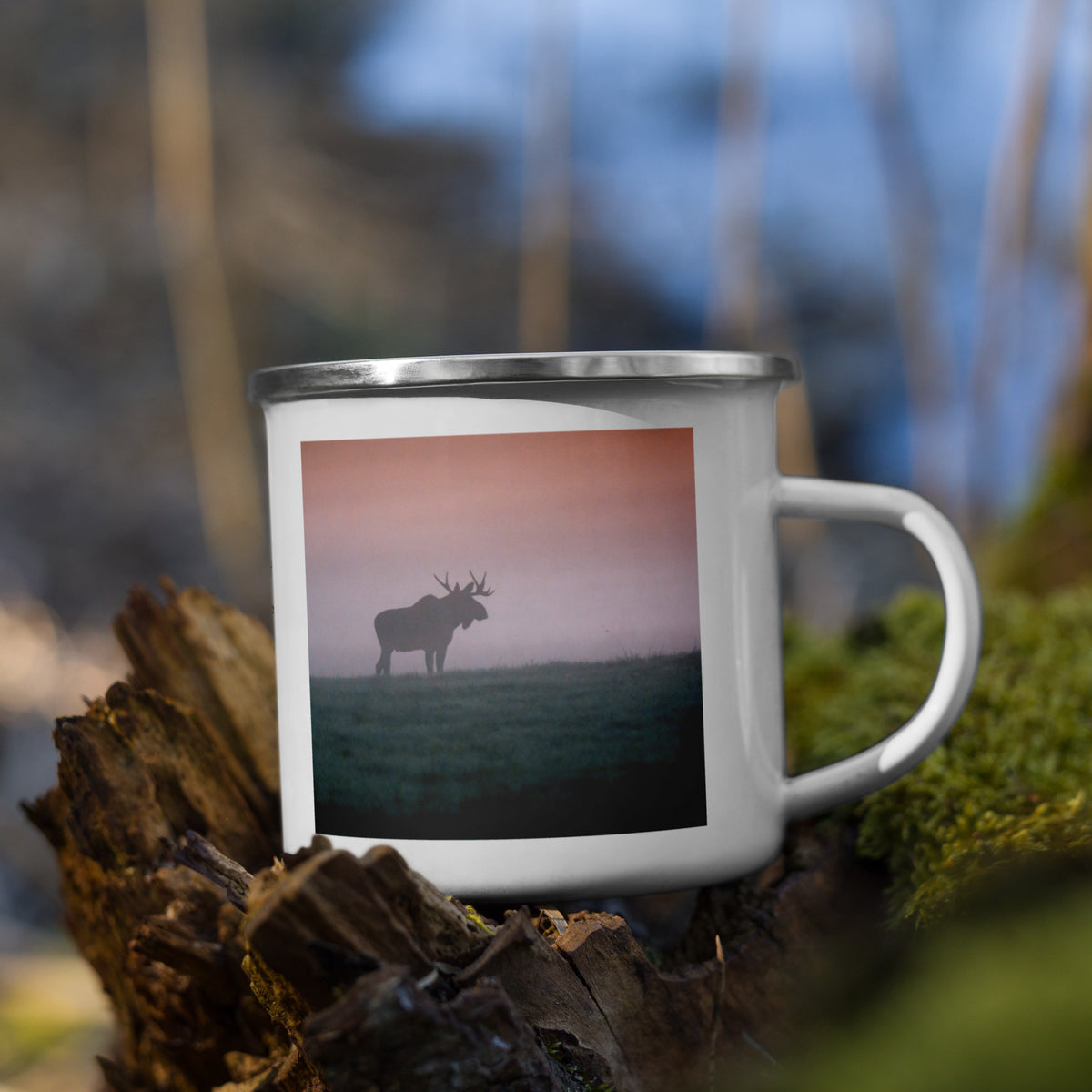 A white enamel camper mug with a silver rim featuring an original photograph of two moose in the mist by Mikko Monto, set in a rustic outdoor environment