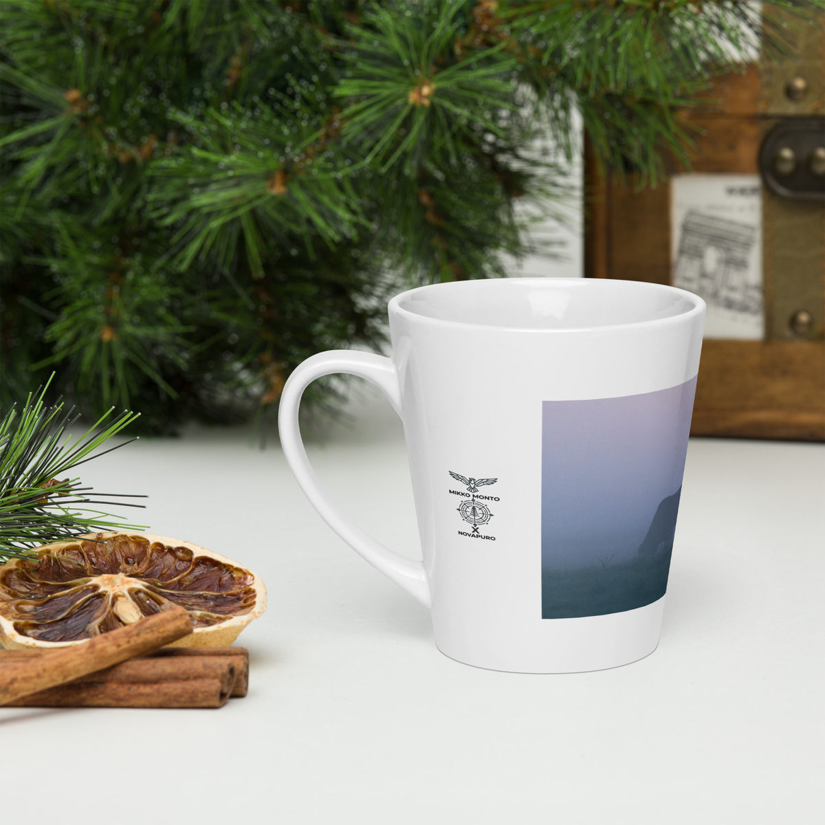 The 12oz Mikko Monto x Novapuro latte mug displaying the beautiful nature photography, placed on a table in a warm, relaxing setting