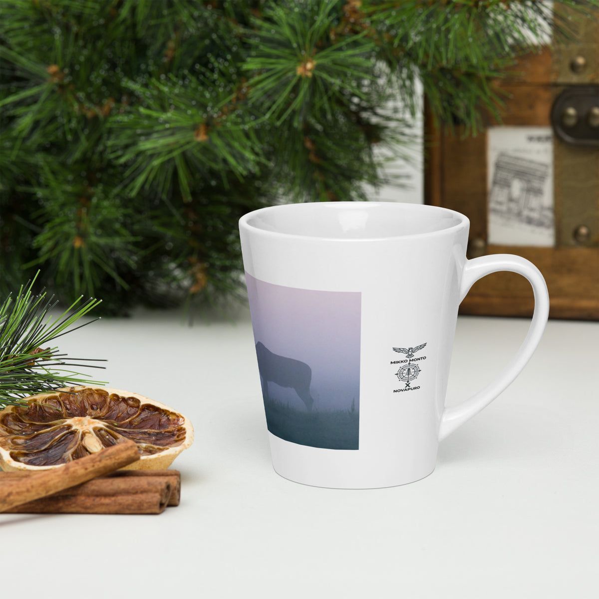 Close-up of the 'Misty Moose' glossy ceramic latte mug next to coffee beans, showcasing the Nordic wildlife art.