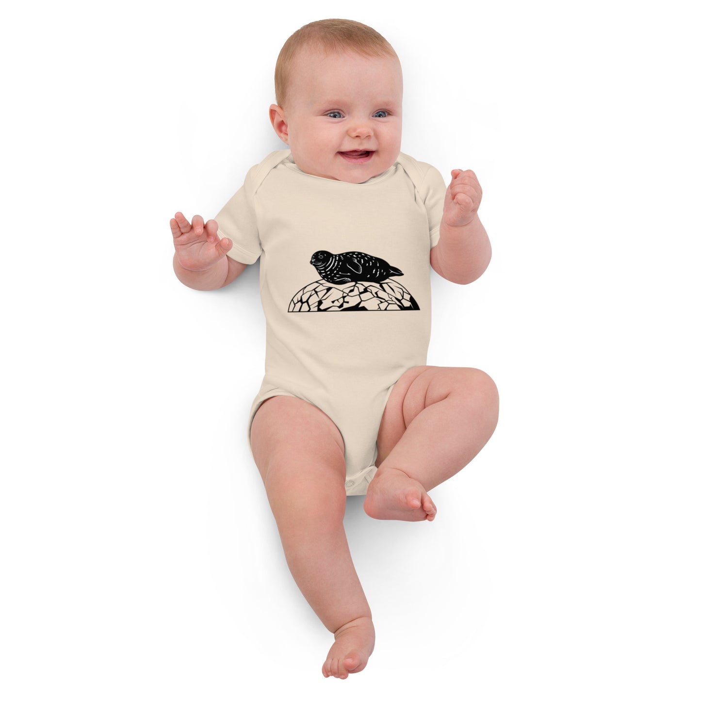 Baby wearing a natural beige Novapuro organic cotton bodysuit featuring a minimalist black Saimaa Ringed Seal wildlife graphic on the chest, white studio background