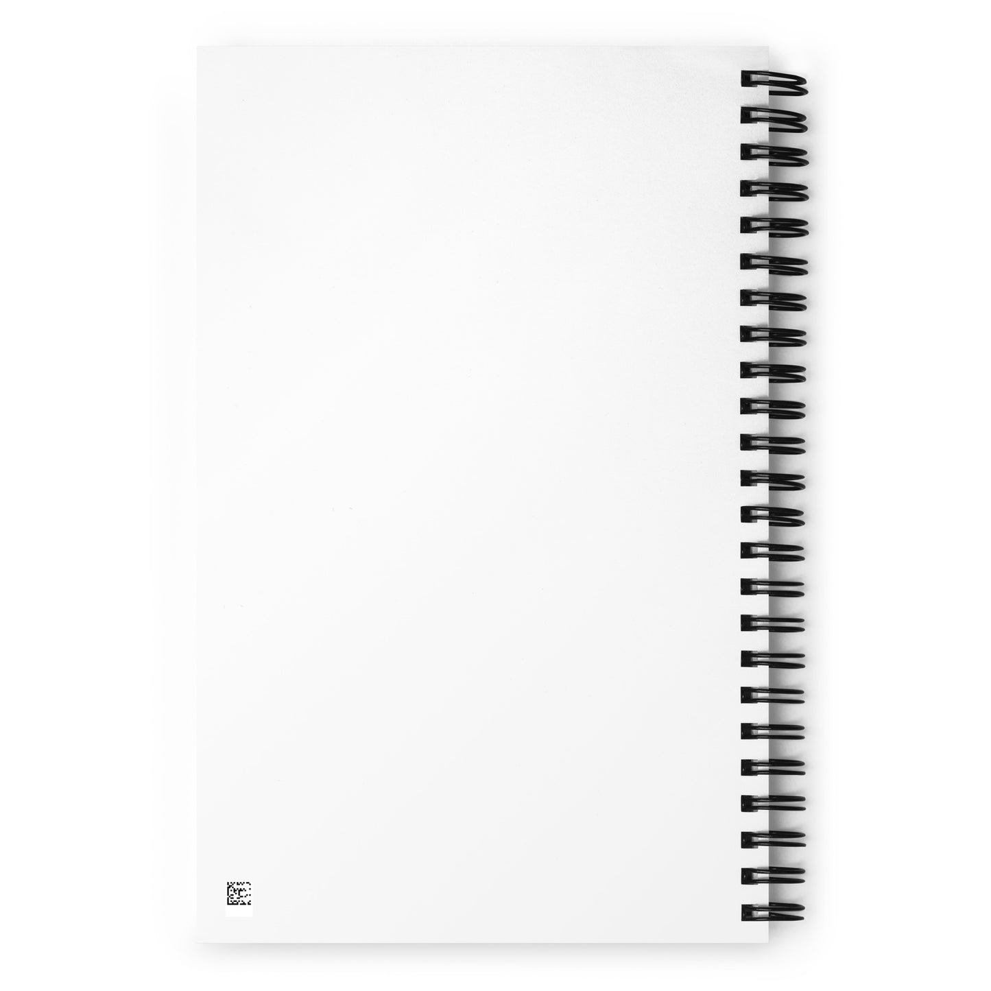 A white spiral-bound notebook laying flat on a desk next to a coffee cup, featuring a minimalist charcoal grey line art illustration of a Nordic lake reflecting a pine tree with the text "STILLNESS".