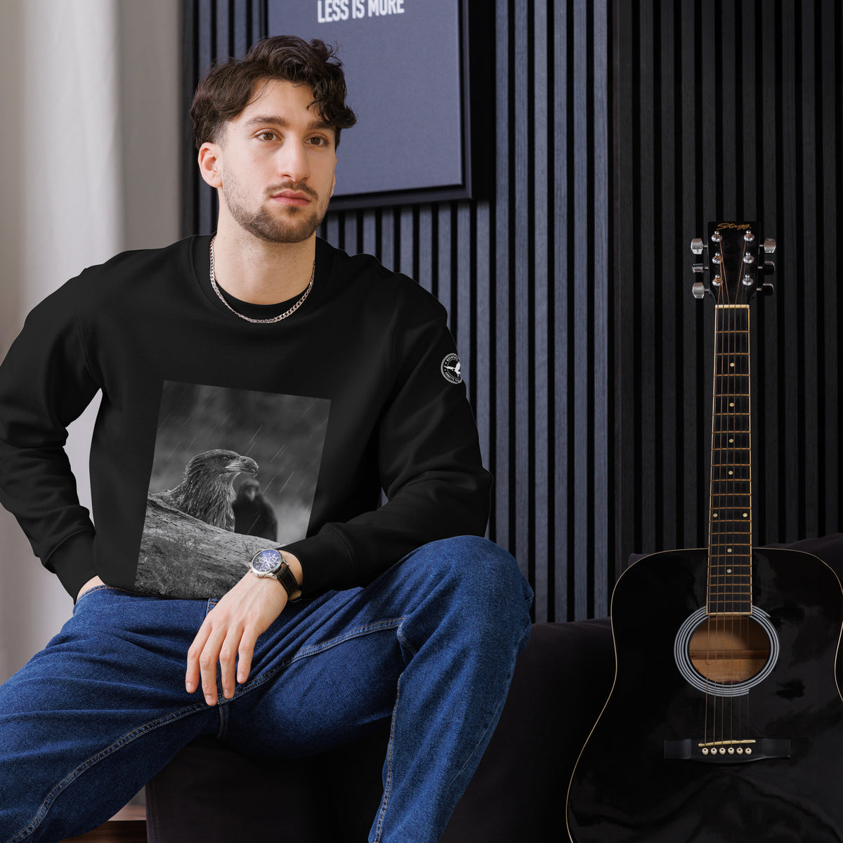 Black unisex organic cotton sweatshirt featuring a minimalist white eagle design on the chest, part of the Annette Thomé-Marttinen x Novapuro sustainable clothing collection.