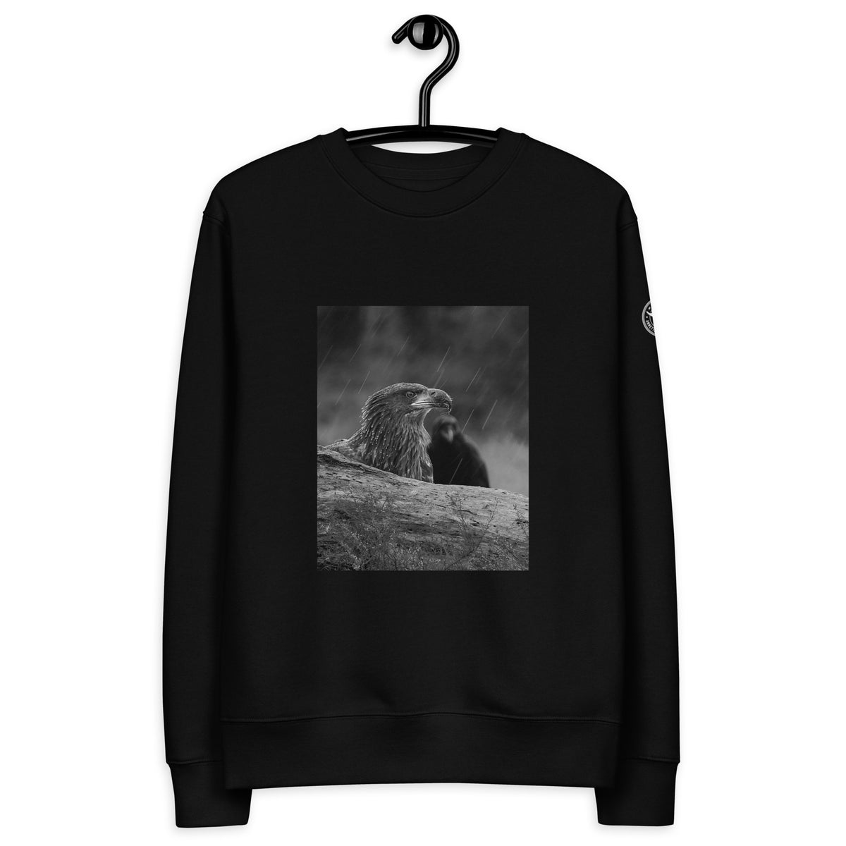 Black unisex organic cotton sweatshirt featuring a minimalist white eagle design on the chest, part of the Annette Thomé-Marttinen x Novapuro sustainable clothing collection.