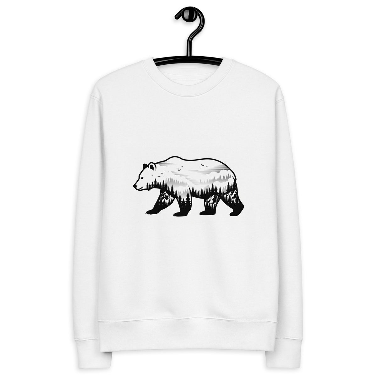 A man standing in a misty Nordic pine forest wearing a sustainable white organic cotton sweatshirt featuring a minimalist bear silhouette design.