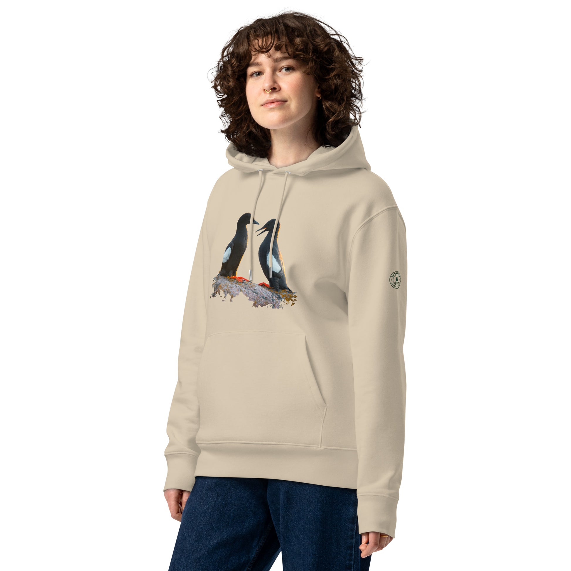 Front view of a female model wearing the sand-colored Jetro Luhtaa x Novapuro organic hoodie featuring a Baltic Guillemots photography print.