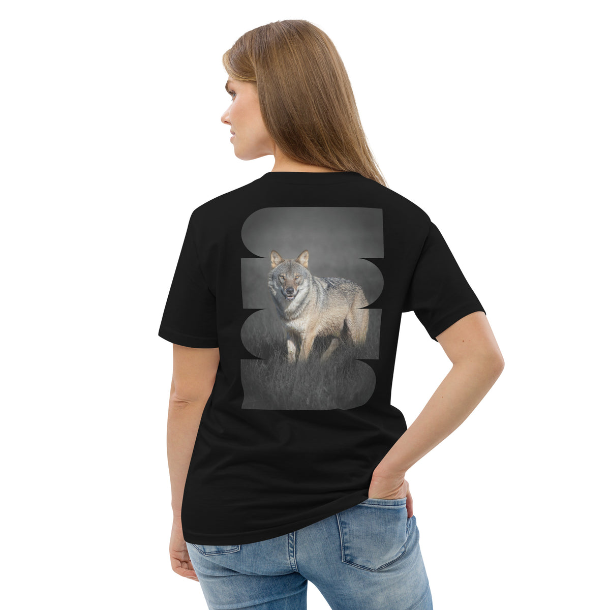 Female model wearing a black unisex organic cotton t-shirt with a striking Dark Alpha Wolf back print. Eco-conscious Scandinavian nature apparel.