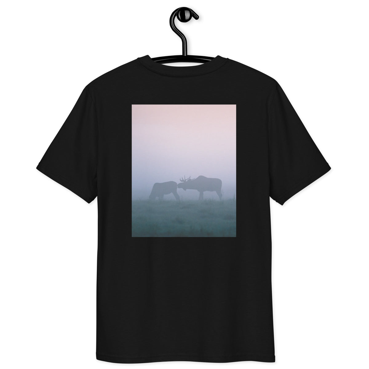 A person wearing a black sustainable organic cotton t-shirt seen from the back, featuring a captivating photograph of two moose in the mist by Mikko Monto."