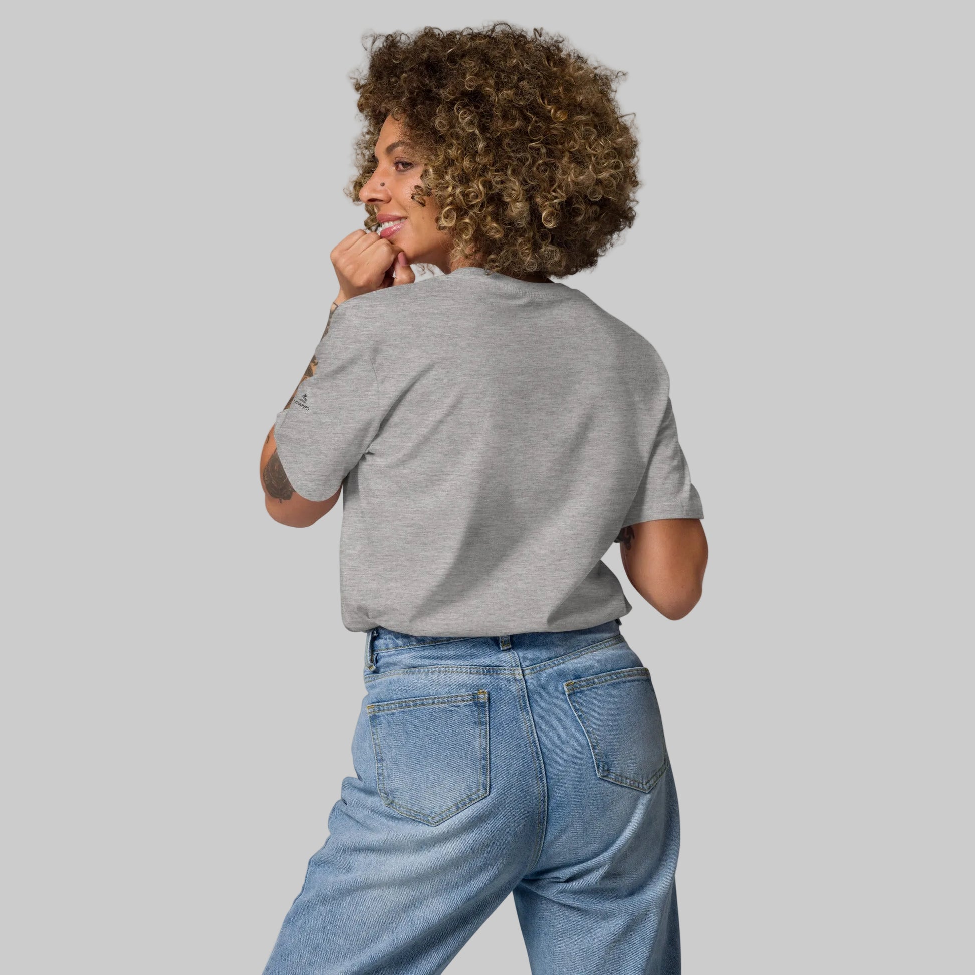 Back view of a female model wearing a heather grey Novapuro soaring bird organic cotton t-shirt.