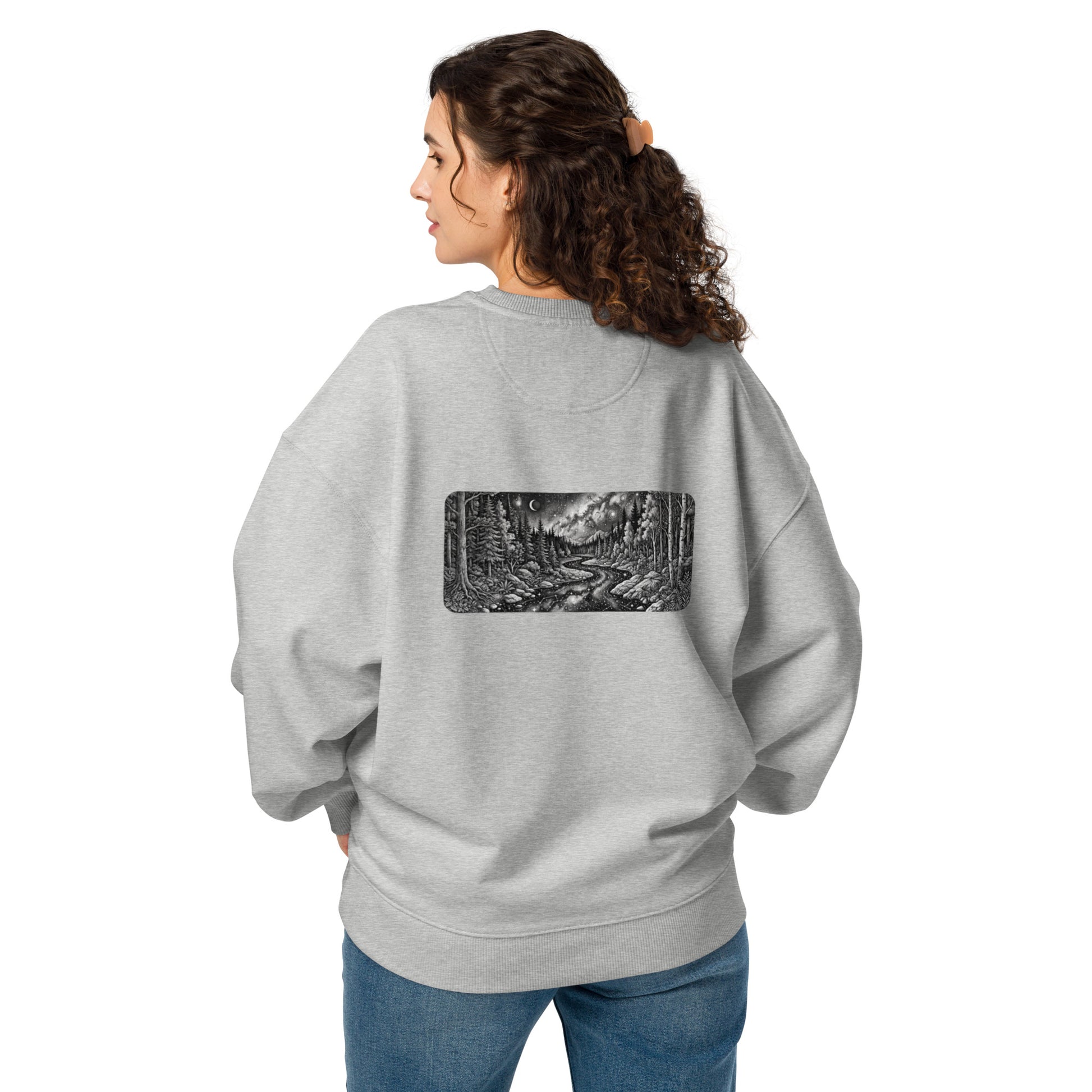Woman wearing the oversized organic sweatshirt from the back, showing the detailed cosmic wilderness and starry night sky art.