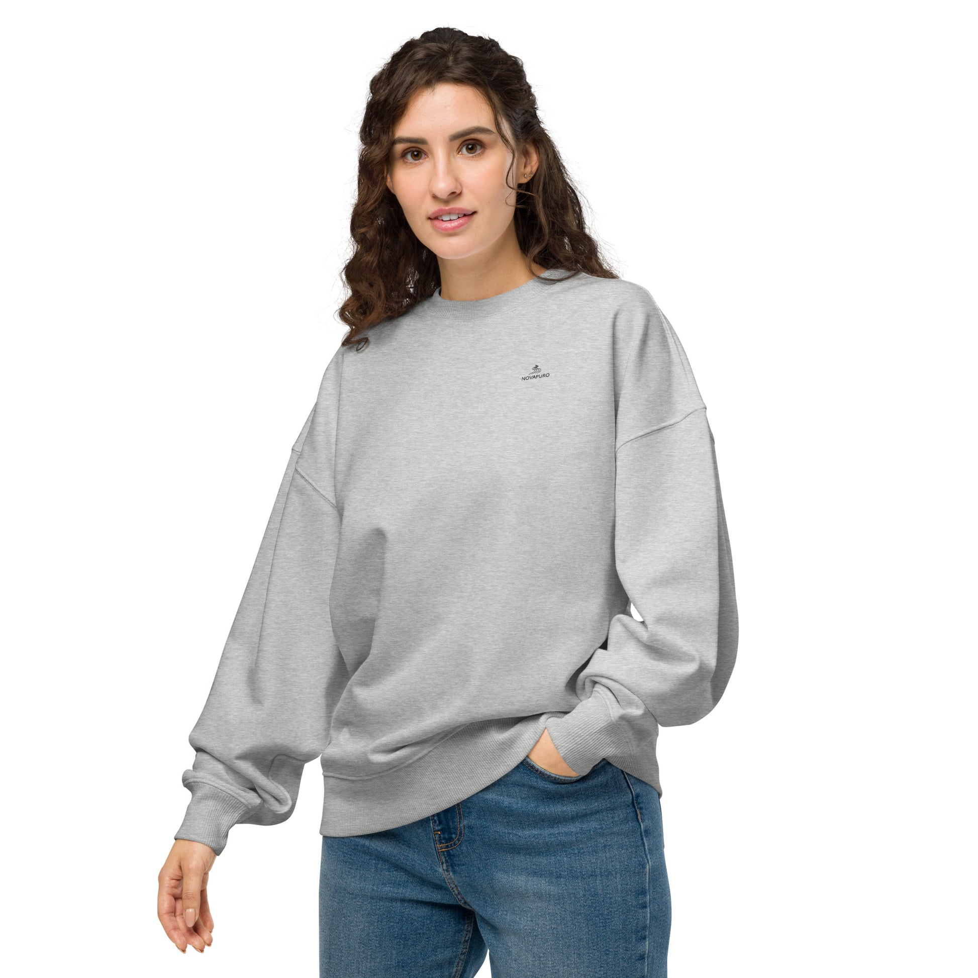 Front view of a woman wearing the grey eco-friendly oversized sweater featuring the minimalist Novapuro logo.