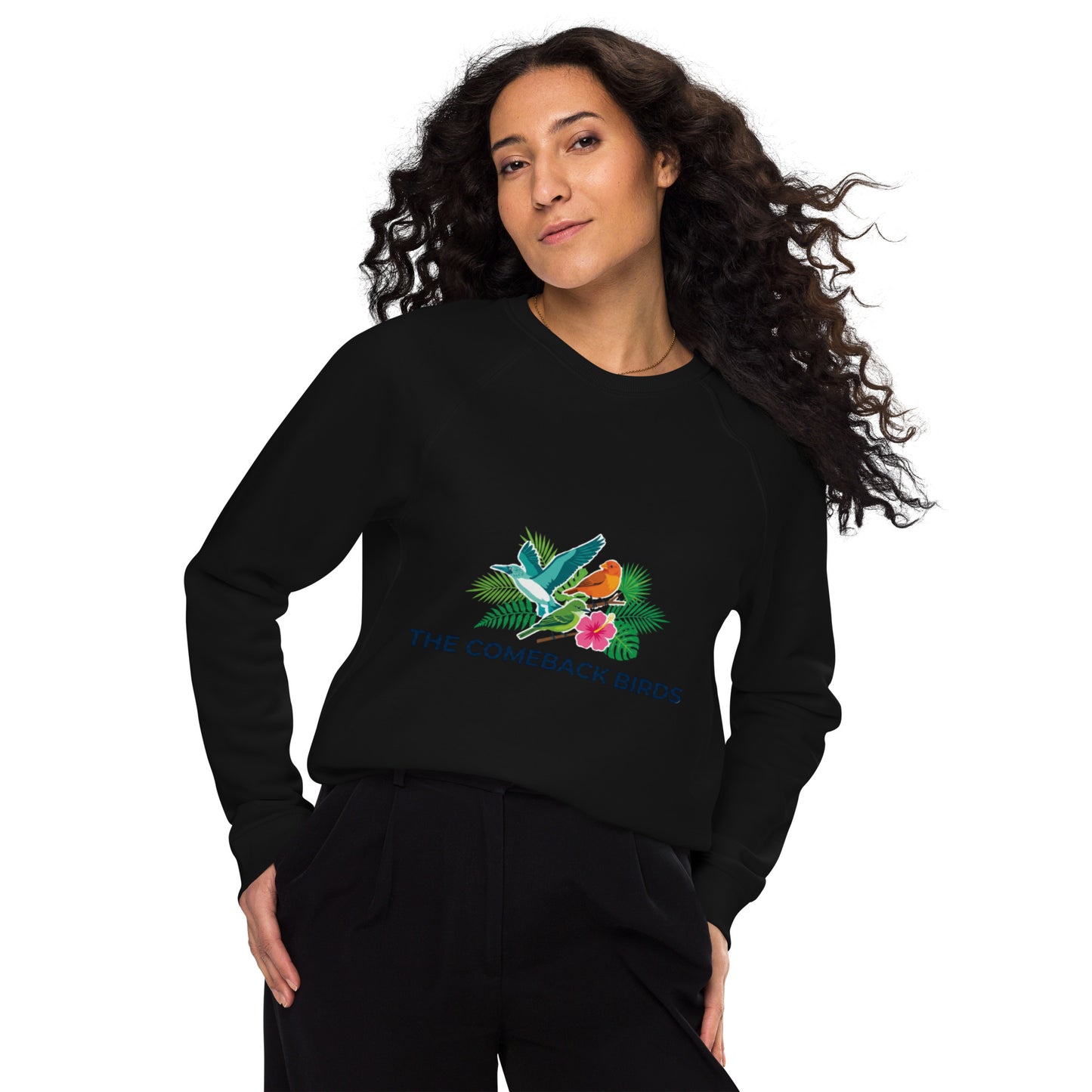 A black unisex organic raglan sweatshirt featuring a colorful graphic of tropical birds, green leaves, and a pink hibiscus flower with the text "THE COMEBACK BIRDS".