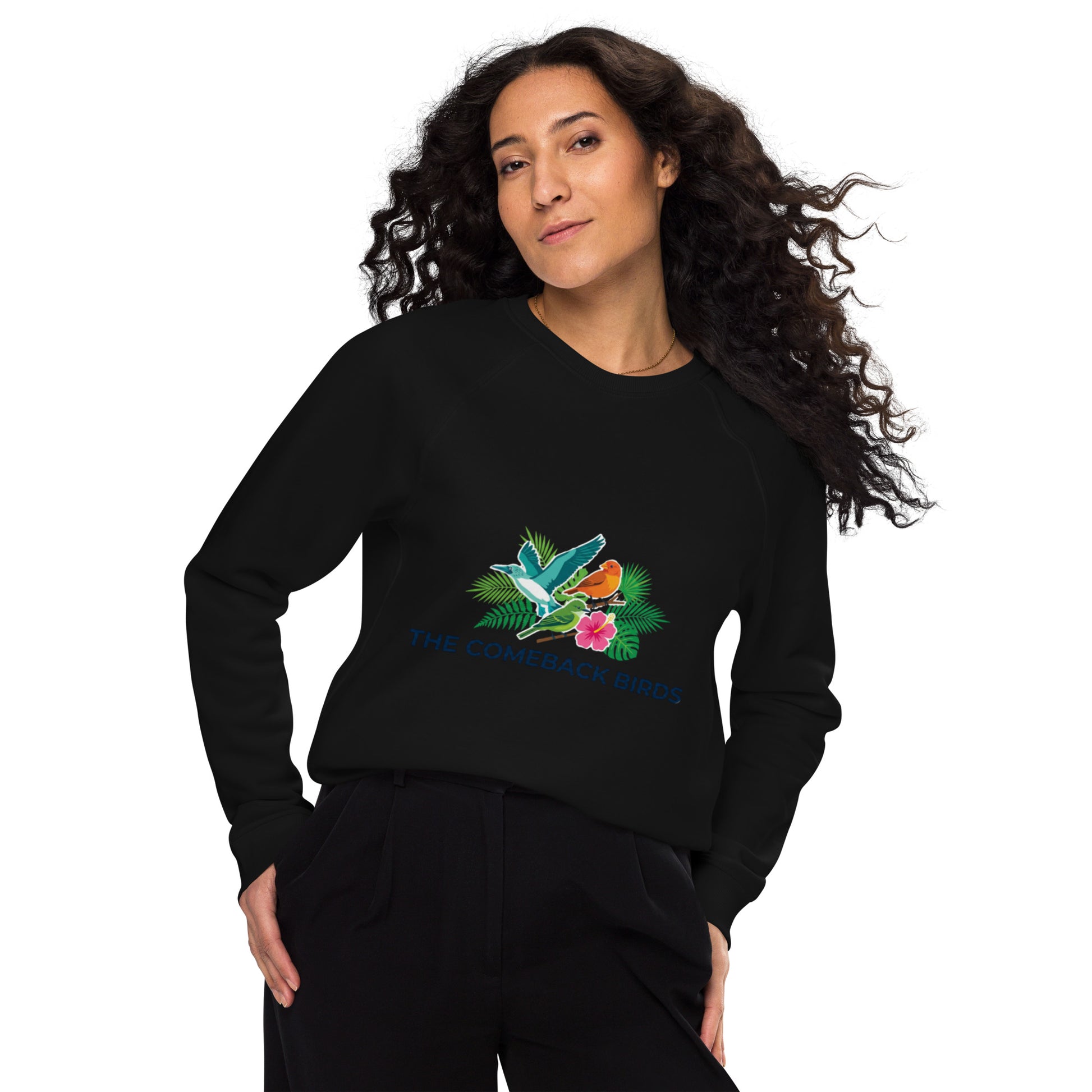 A black unisex organic raglan sweatshirt featuring a colorful graphic of tropical birds, green leaves, and a pink hibiscus flower with the text "THE COMEBACK BIRDS".