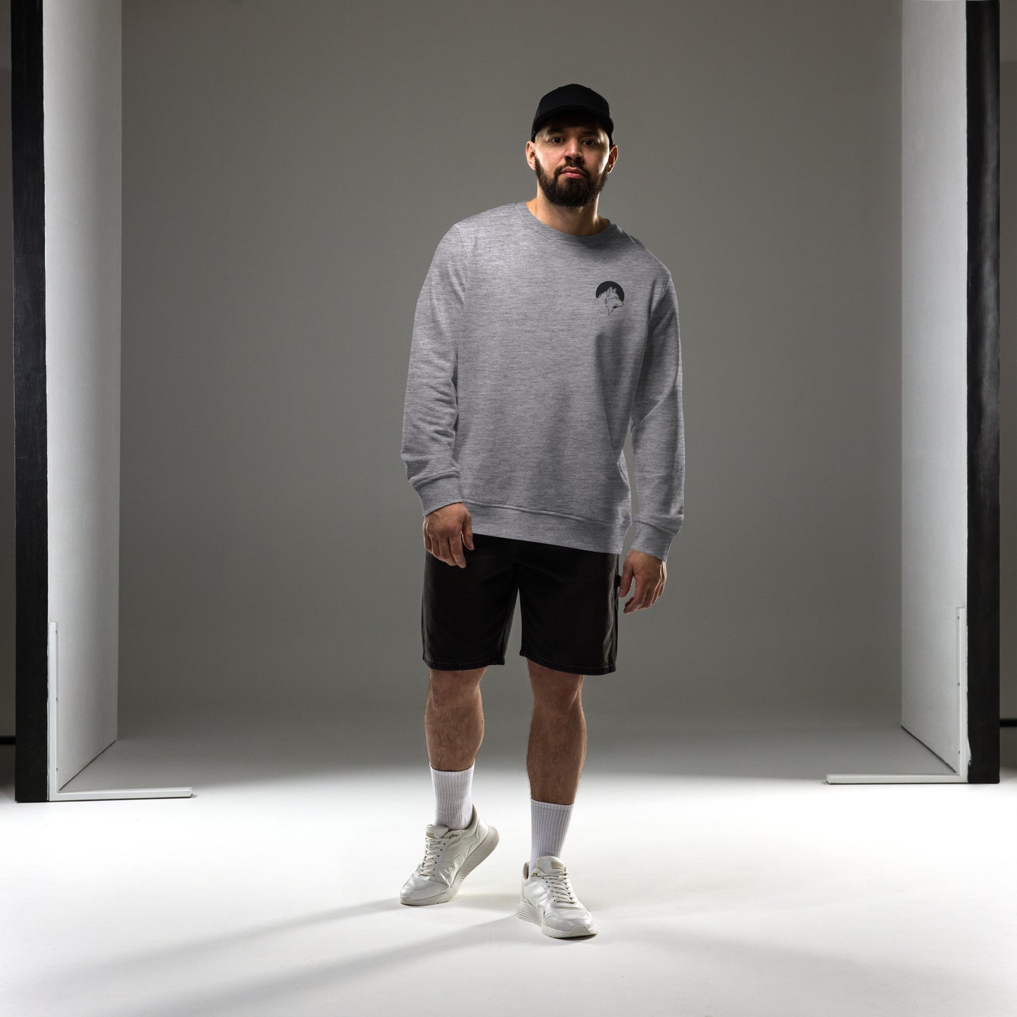 A man wearing a grey sustainable organic cotton sweatshirt with a minimalist wolf line art logo, demonstrating Nordic lifestyle fashion.